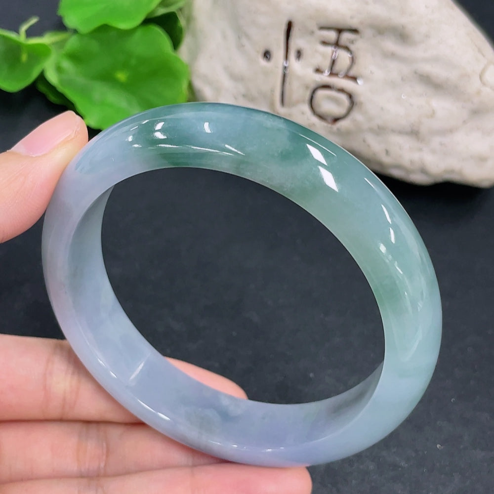 HKHQ jadeite round bangle with size 65 and 83.3g weight, showcasing smooth, polished green jadeite bracelet on a neutral background.