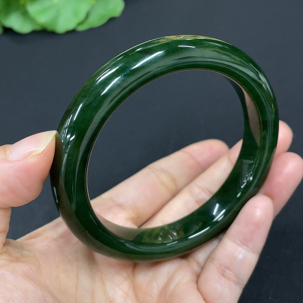 Green Hetian Jade round bangle bracelet with smooth, polished surface, crafted by HKHQ, showcasing elegant jewelry design.
