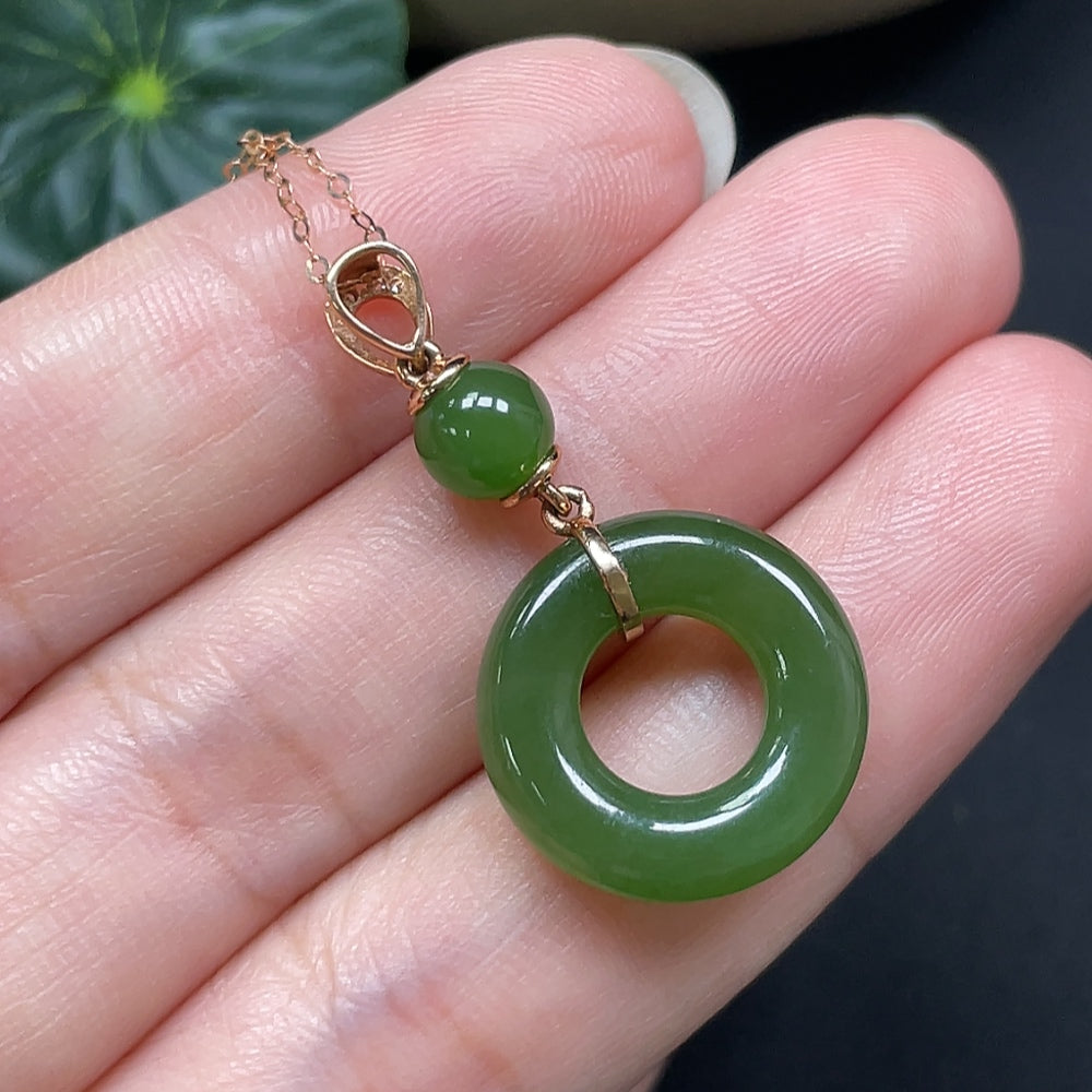 Hetian jade peace knot pendant with 18K gold accents and diamond details, showcasing intricate craftsmanship and elegant design.