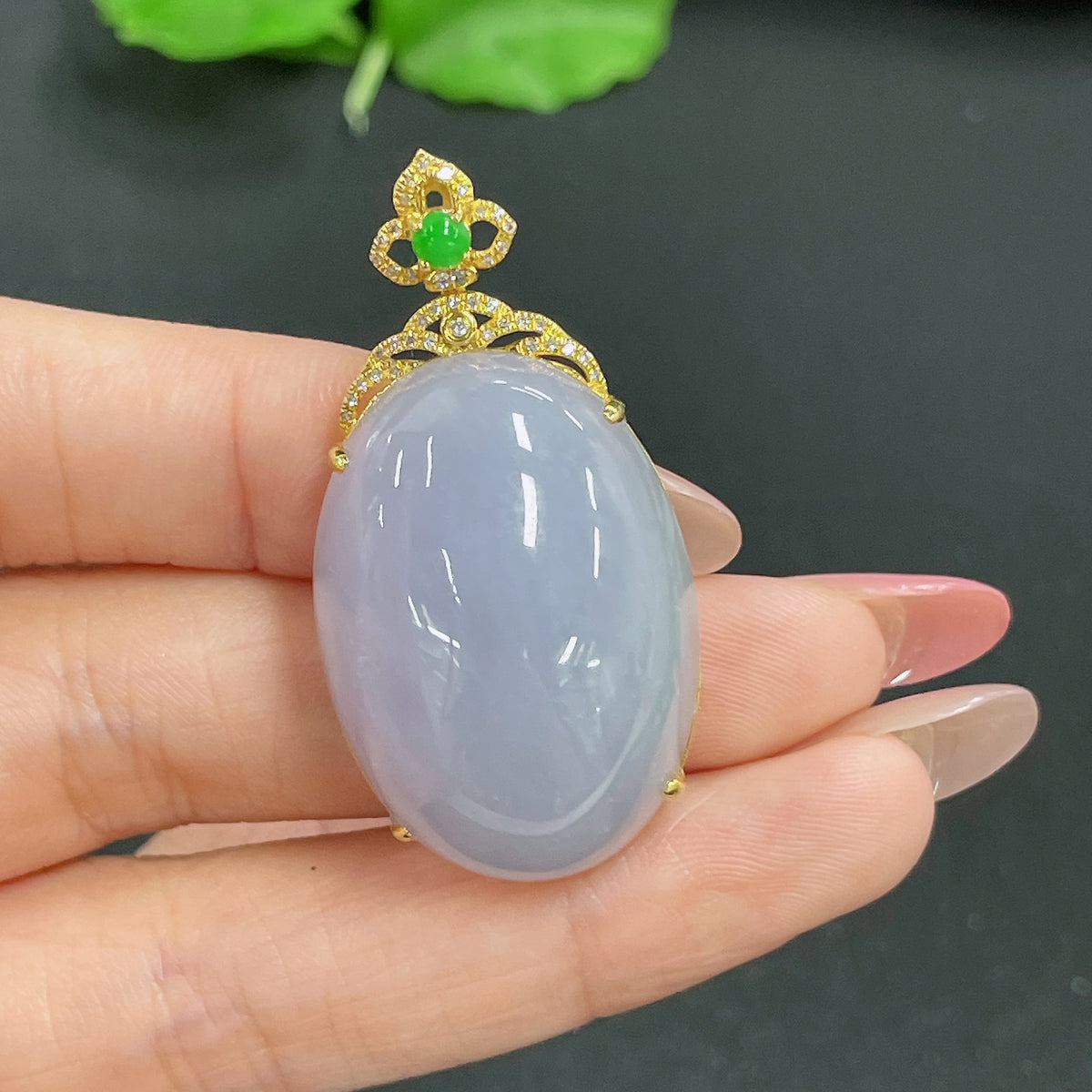 Jadeite pendant with 18k gold inlay and diamond accents, featuring a polished green jade stone on a delicate chain.
