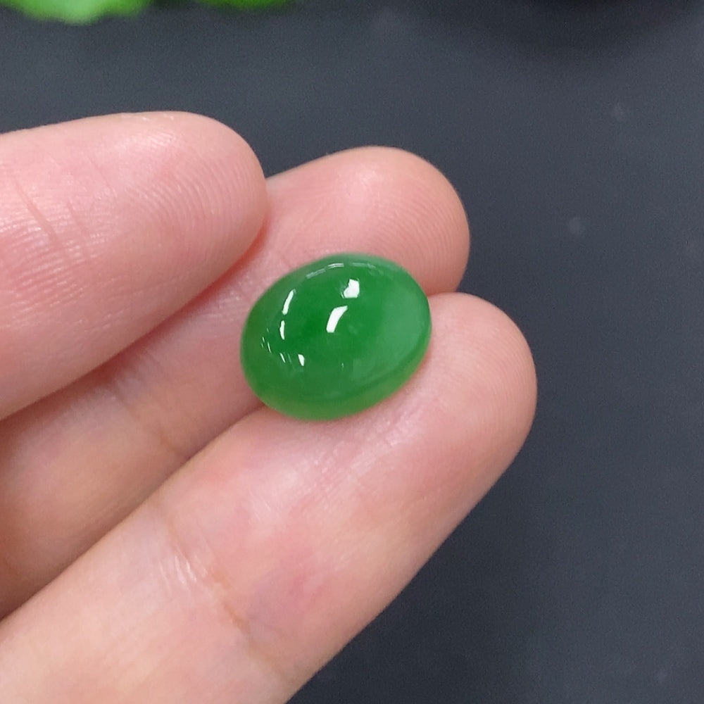Close-up of a HKHQ jadeite cabochon jewelry piece, approximately 1.1g, showcasing smooth, polished green gemstone.
