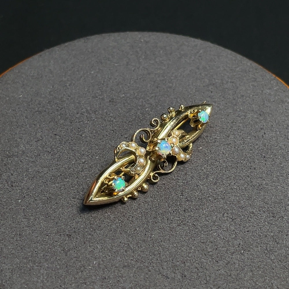 HKHQ opal brooch with accent stones, 55% gold, featuring a vibrant opal gemstone and decorative non-natural accent stones.