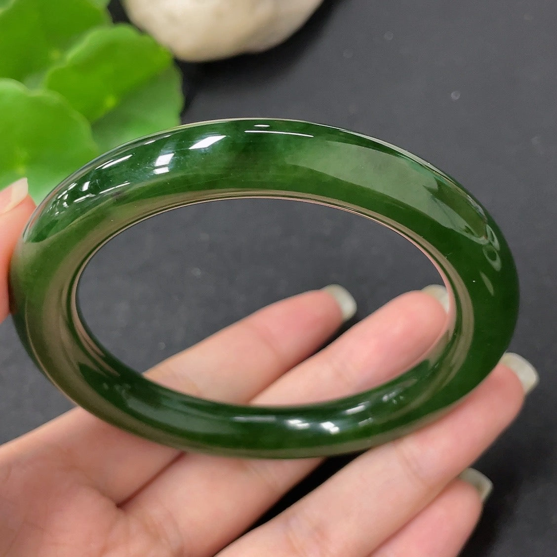 Green Hetian Jade round bangle with smooth surface, HKHQ brand, size 58.7, weight approximately 56.9g, showcasing intricate jade craftsmanship.