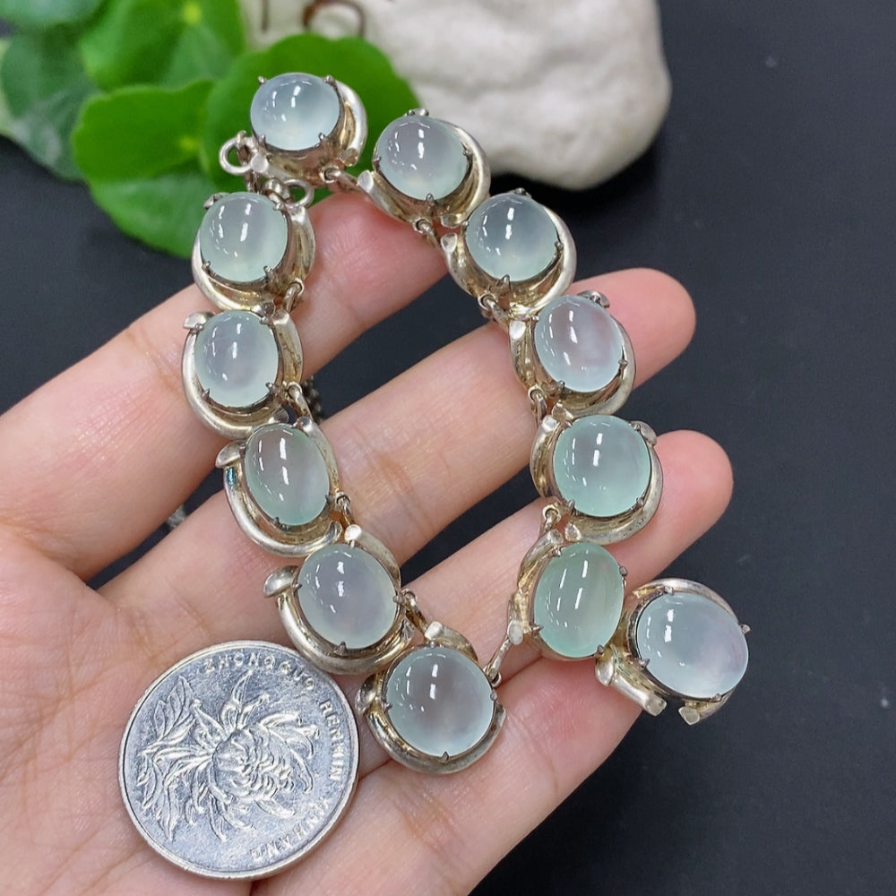 Jadeite cabochon gemstone in a non-gold setting, weighing approximately 61.2 grams, displayed on a neutral background.