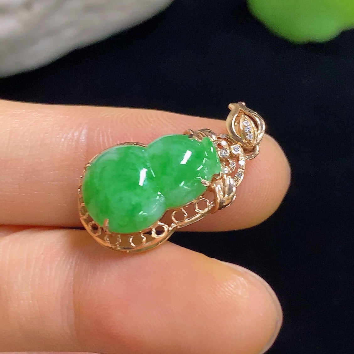 Jadeite gourd pendant with 18k gold inlay and diamond accents, featuring a smooth jade surface and intricate craftsmanship.