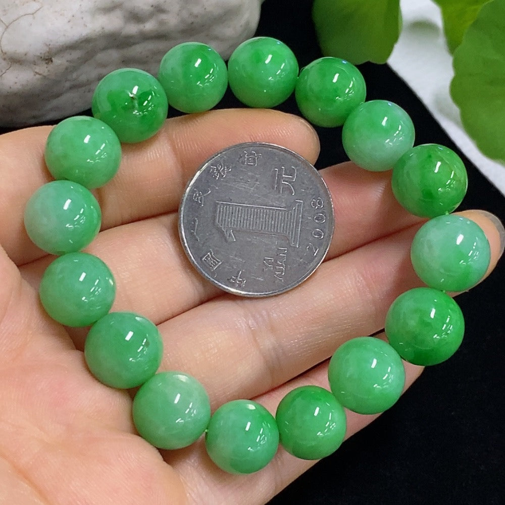 Jadeite bracelet with 11mm jade beads, approximately 43g, displayed on a neutral background showcasing its smooth, polished surface.
