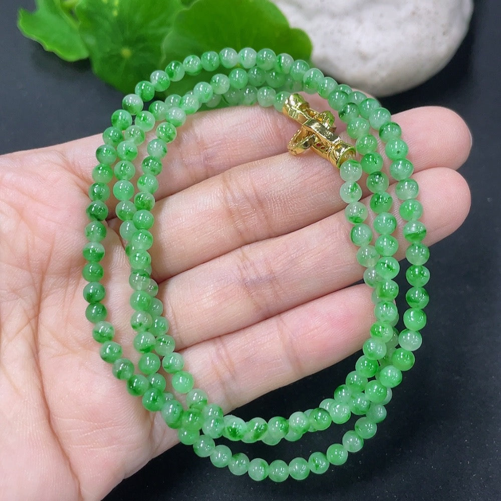 Jadeite bead necklace by HKHQ featuring non-gold mineral components, showcasing smooth green jadeite beads on a jewelry strand.