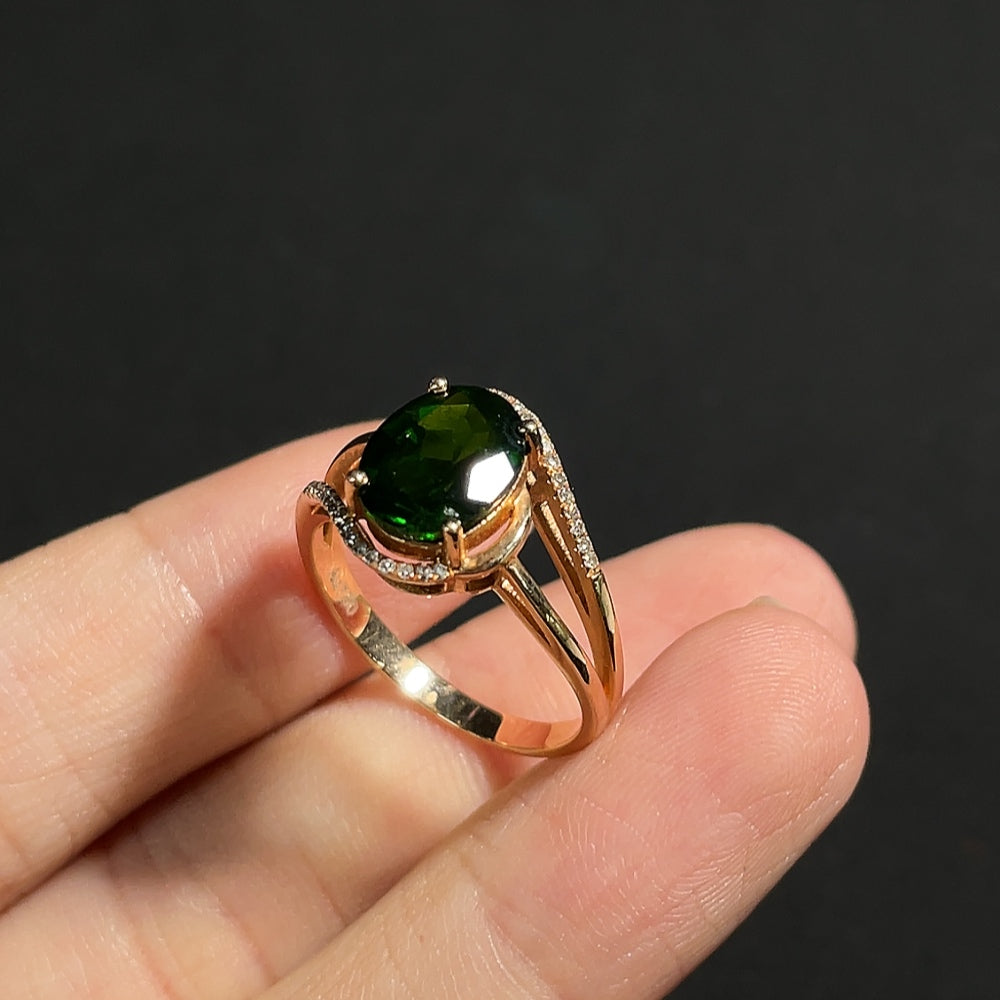Diopside ring with diamond accents set in 18K gold, featuring a polished band and sparkling gemstone centerpiece.