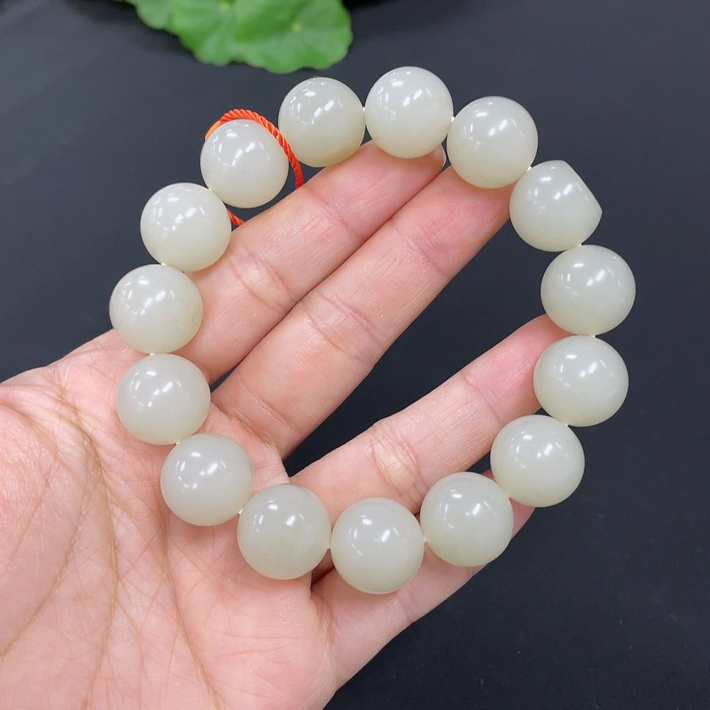 HKHQ Hetian Jade bracelet with 13.9mm beads and 64.2g weight, featuring smooth, polished jade stones on a natural skin tone.