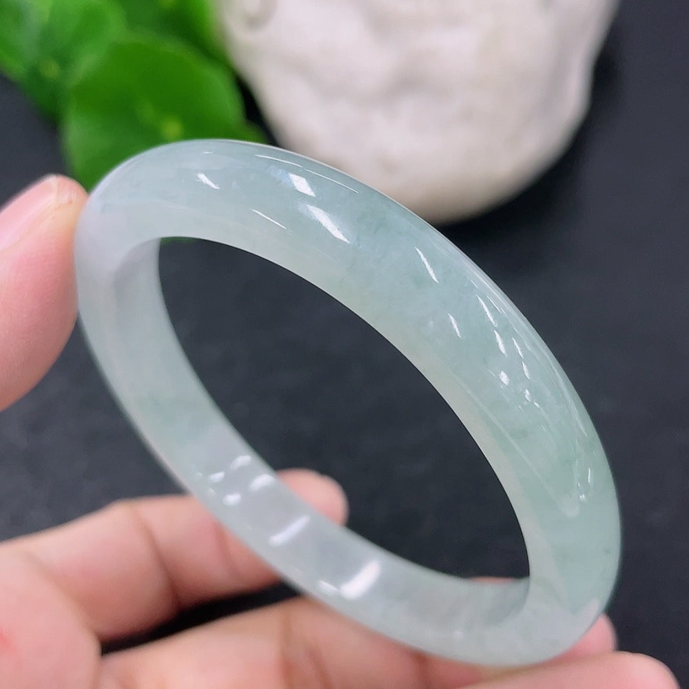 HKHQ jadeite oval bangle in size 52.8 with 27.69g, showcasing smooth, polished jadeite bracelet on a neutral background.