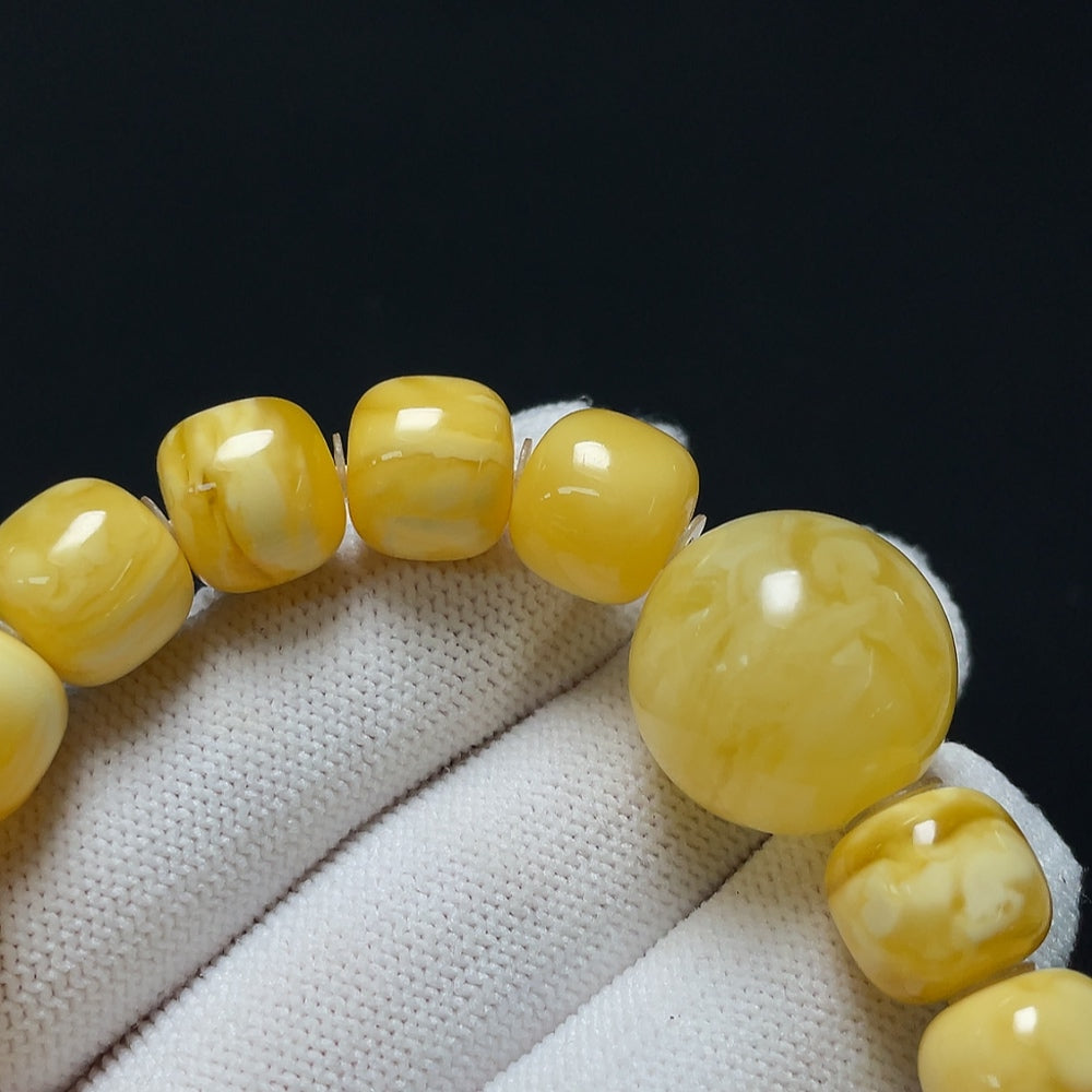 Amber beeswax bracelet by HKHQ with visible repairs, weighing 19.22g, size 11.4-18.8mm, featuring warm amber hues and natural texture.