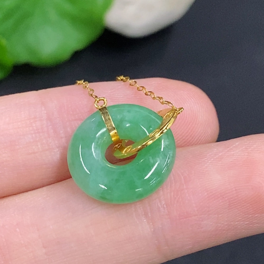 Jadeite donut pendant by HKHQ in 18k gold, featuring a smooth, polished green jade stone with a gold chain.