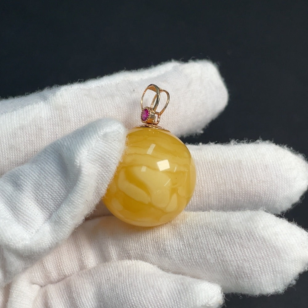 Amber beeswax pendant with 18K gold setting, featuring natural gemstone details and intricate design by HKHQ.