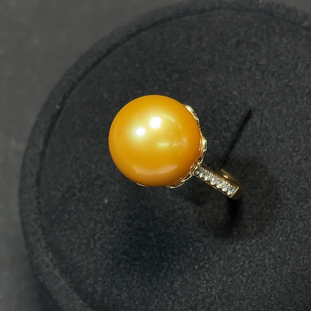 Elegant saltwater pearl and diamond ring in 18K gold, featuring intricate design and sparkling gemstones.