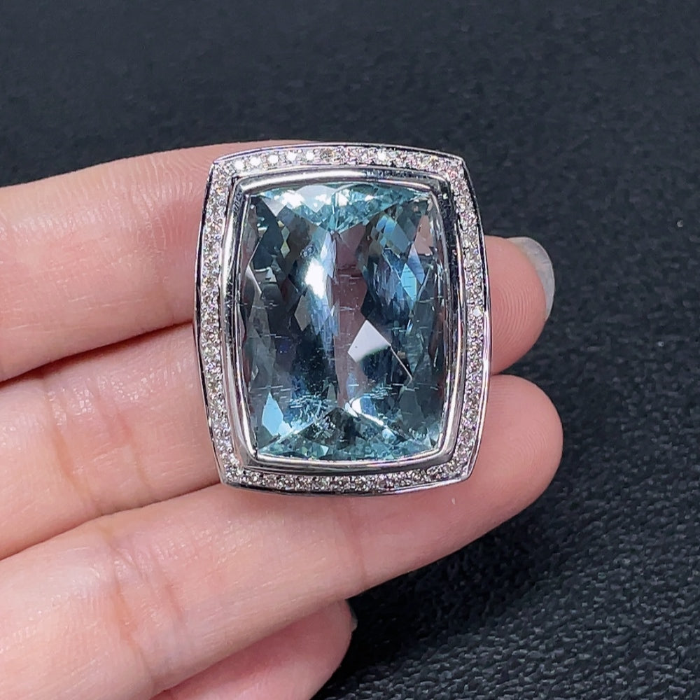 Aquamarine pendant with diamond accents in 18K gold, showcasing a sparkling gemstone and intricate design.
