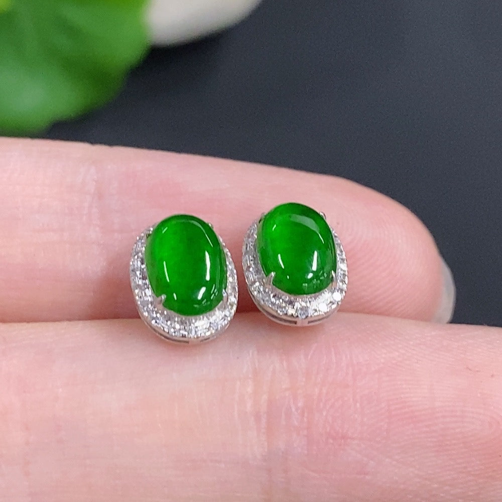 Jadeite cabochon stud earrings in 18k gold with diamond accents, featuring smooth green jade stones and gold posts.