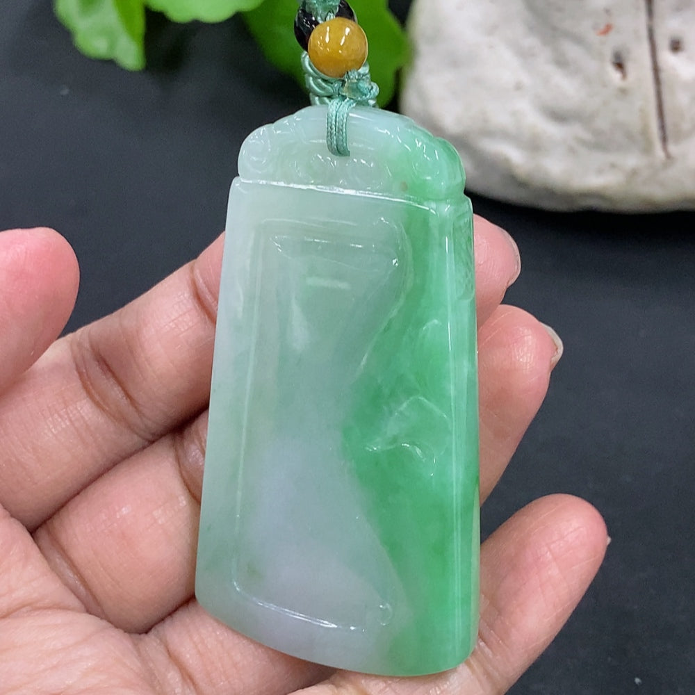 Antique jadeite pendant on a necklace, weighing approximately 32g, featuring intricate carvings and rich green color, from HKHQ.