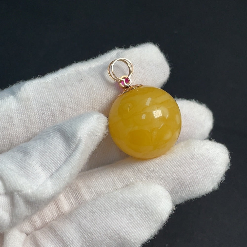 Amber beeswax pendant with 18K gold setting featuring natural gemstone, crafted by HKHQ.