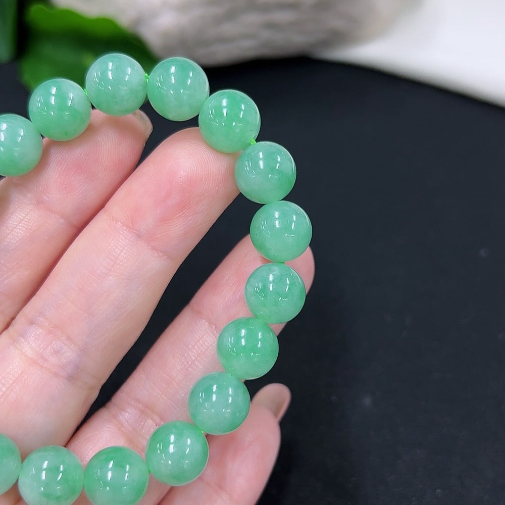 Jadeite bracelet with 9.5mm beads, HKHQ brand, showcasing smooth green jade stones with a polished finish.