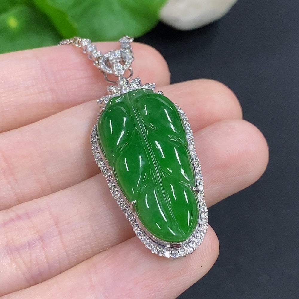 Jadeite leaf pendant with 18K gold accents and diamond details, shown on a chain, weighing approximately 12g.