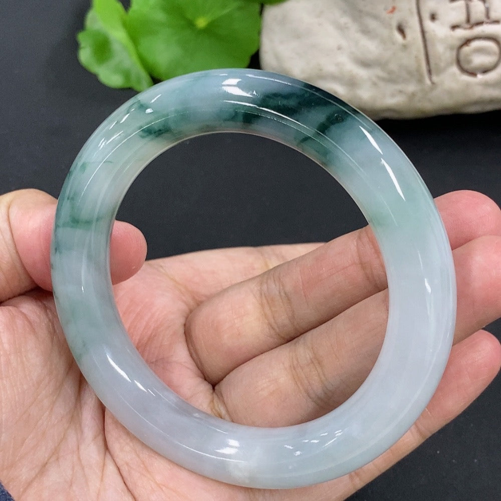 HKHQ jadeite round bangle, size 54.9, weighs approx. 65.2g, featuring green jade with mineral inclusions.