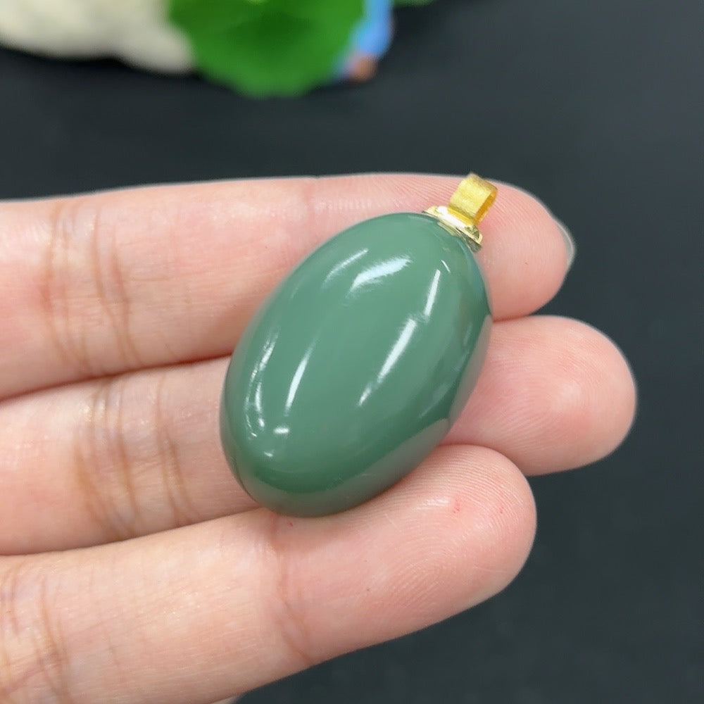 Hetian jade inlaid pendant with 18k gold setting, weighing approximately 12.7g, featuring intricate craftsmanship and polished finish.