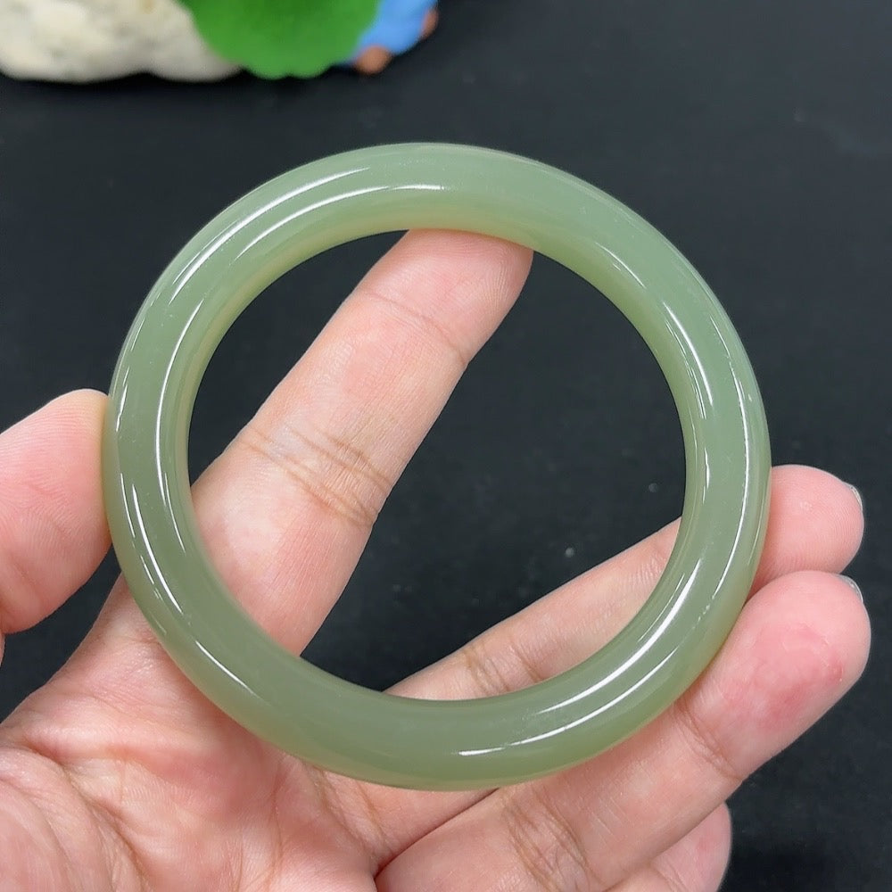 HKHQ Hetian Jade round bangle, size 56.9, weighing approx. 49.3g, showcasing smooth, polished green jade surface.