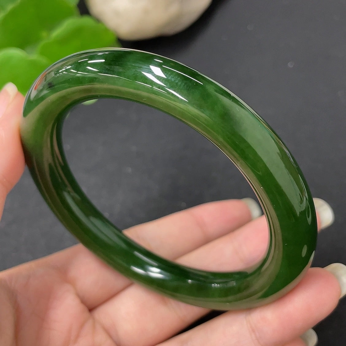 Green Hetian jade round bangle with natural polish, HKHQ brand, size 58.7mm, weight approximately 56.9g, showcasing smooth, glossy surface.
