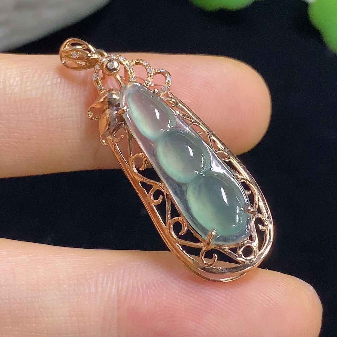Jadeite auspicious bean pendant with 18K gold accents and diamond details, weighing approximately 2.23g.