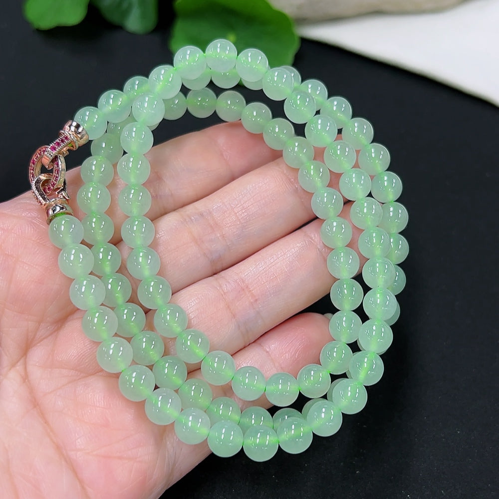HKHQ jadeite bead necklace with 6.6mm round beads, non-gold inlaid, showcasing a smooth, polished green jadeite string.
