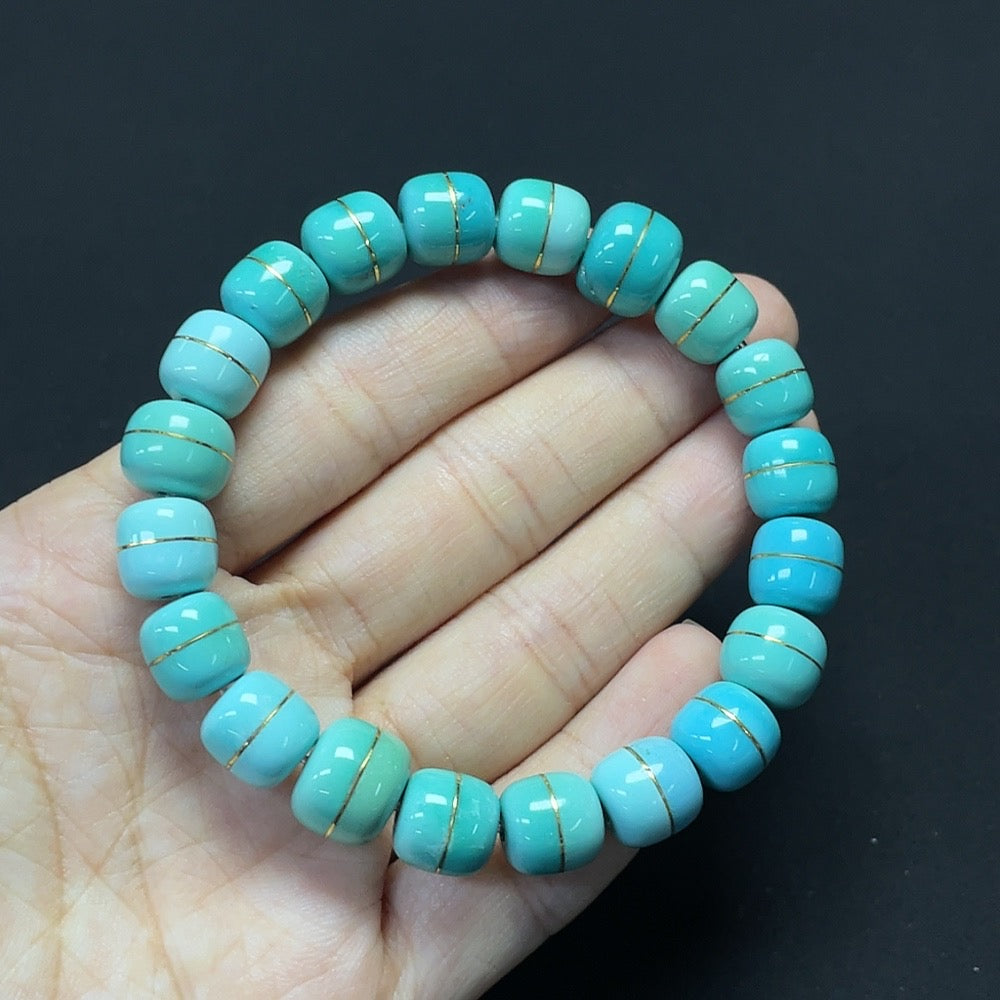 HKHQ turquoise gemstone bracelet with gold content and stone inclusions, approximately 8.9-10.7mm, weighing about 26.98g.