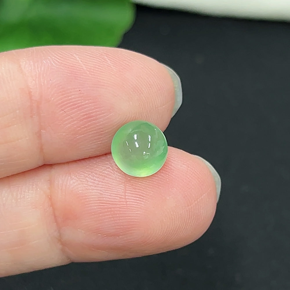 Small jadeite cabochon jewelry piece from HKHQ, showcasing a smooth, polished green gemstone with a glossy surface.