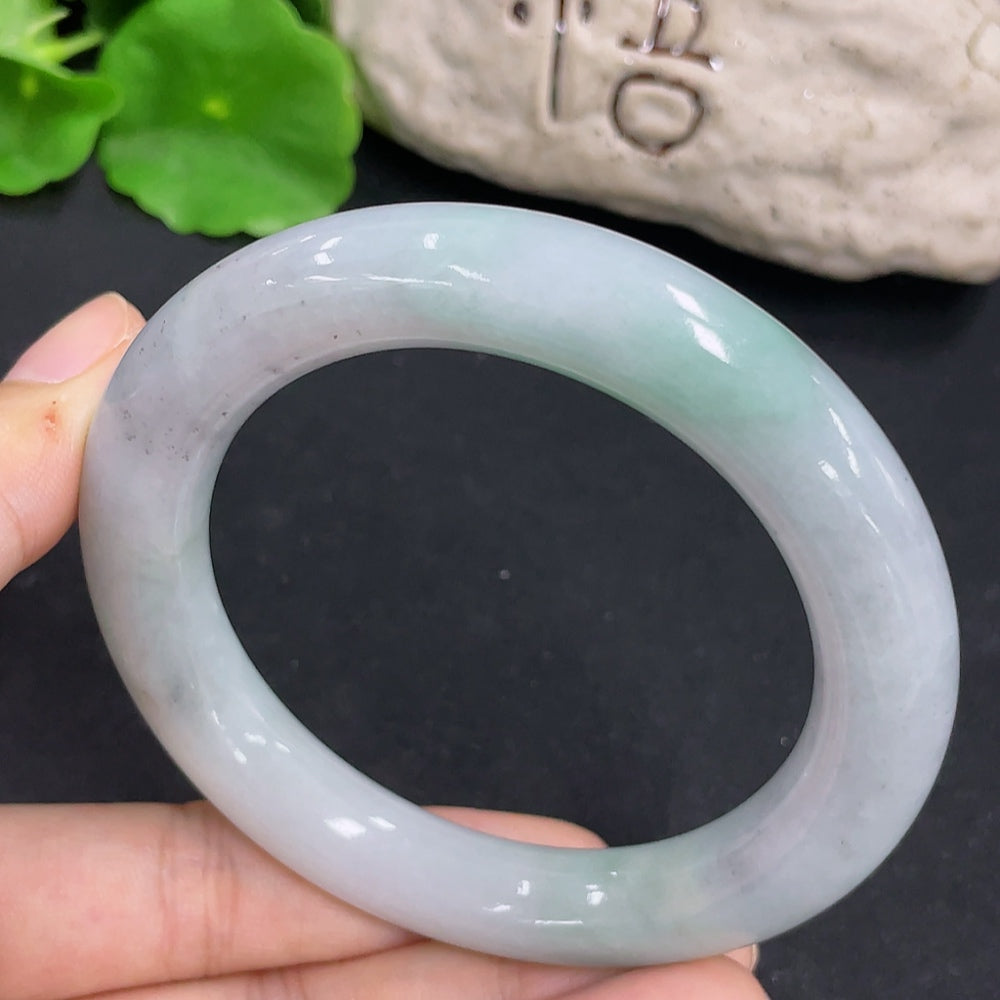 Smooth jadeite round bangle from HKHQ, showcasing its polished green jade surface and elegant circular design.