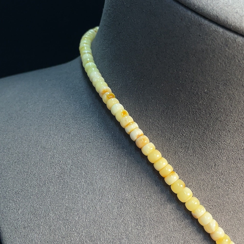 Amber beeswax pendant with a colorless coating, partial repairs visible, weighing 35.77g, with cord and collection certificate.