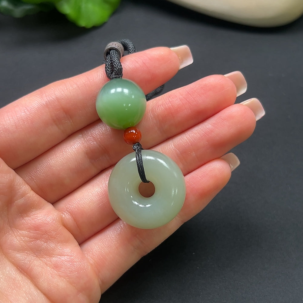 Hetian Jade Peace Knot Pendant with Southern Red, HKHQ, featuring intricate design and a red rope, weighs approximately 22.9g.