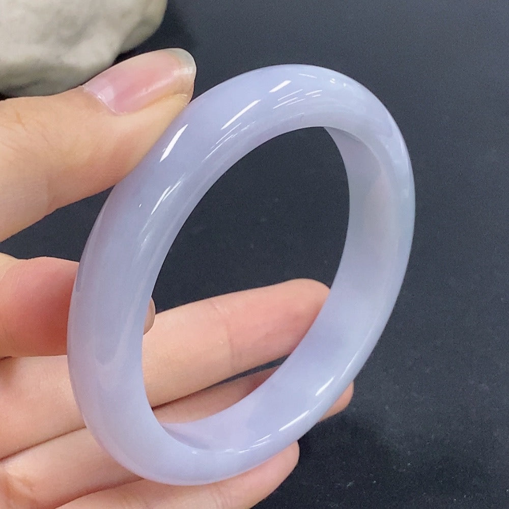 Round jadeite bangle with a smooth finish, size 56.1, weighing approximately 53.9g, showcased against a neutral background.
