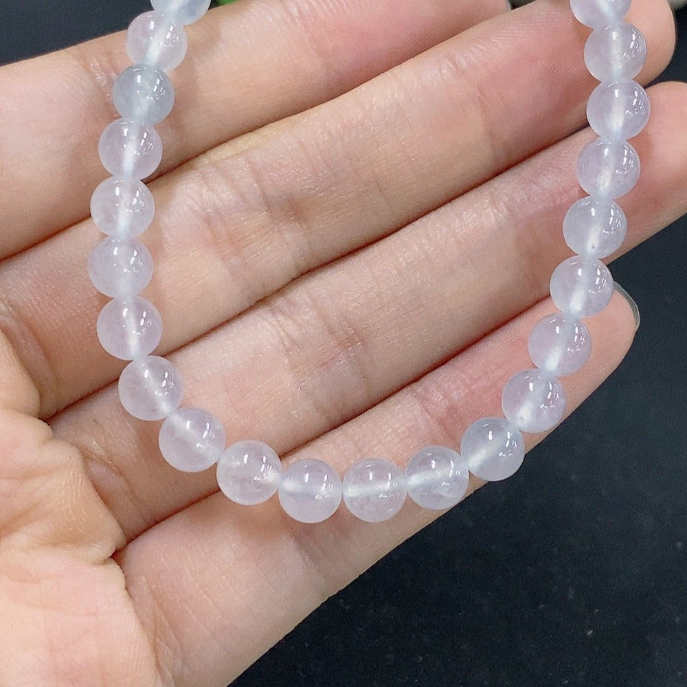 HKHQ jadeite bracelet with 5.9mm beads, approximately 10.8g, featuring smooth, polished jade stones on a string.
