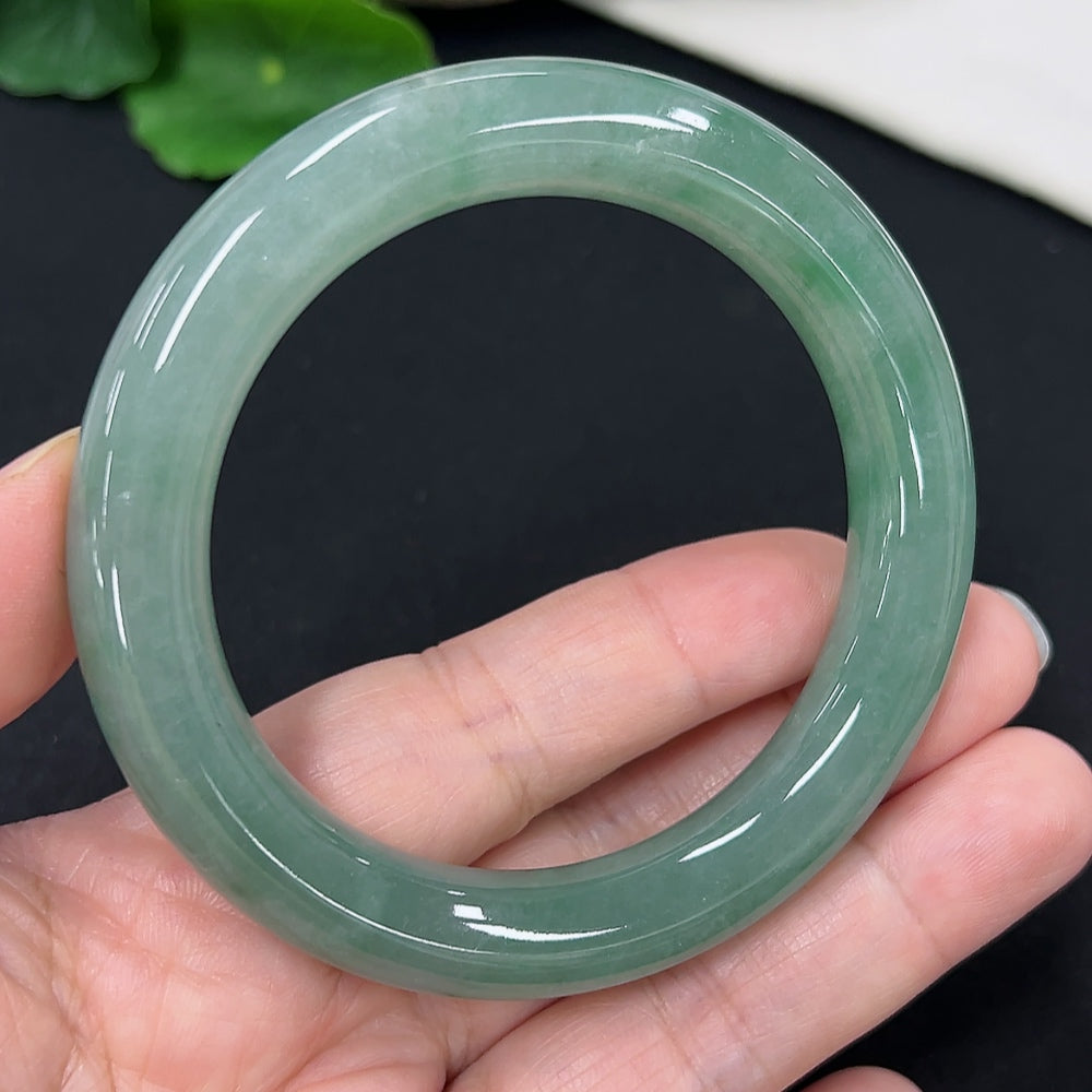 Jadeite round bangle in size 54.3, weighing approximately 58.4g, showcasing smooth, polished green jade material.