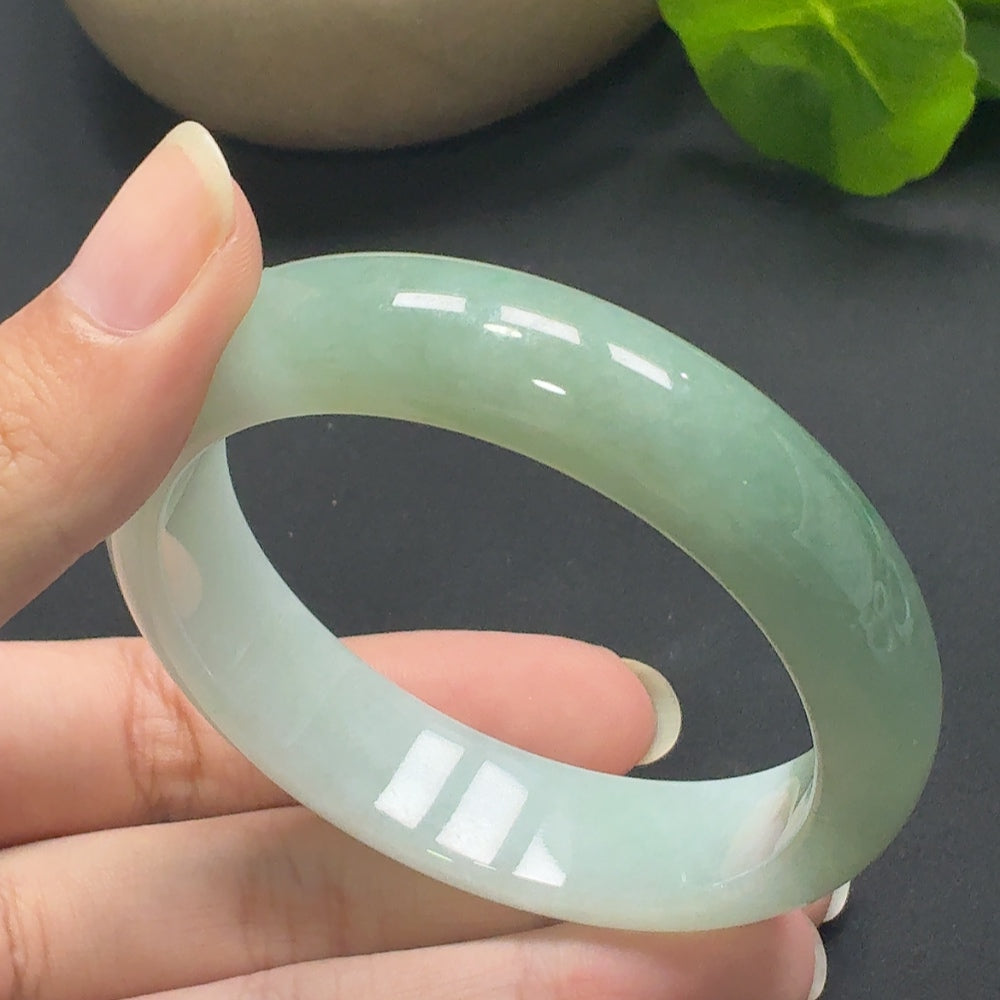Jadeite round bangle with size 55.6 and weight 60.26g, showcasing smooth, polished jade surface and elegant craftsmanship.