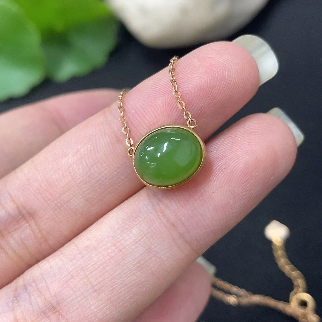 Hetian Jade inlaid pendant necklace with 18k gold setting, HKHQ brand, featuring a jade stone and a delicate chain.