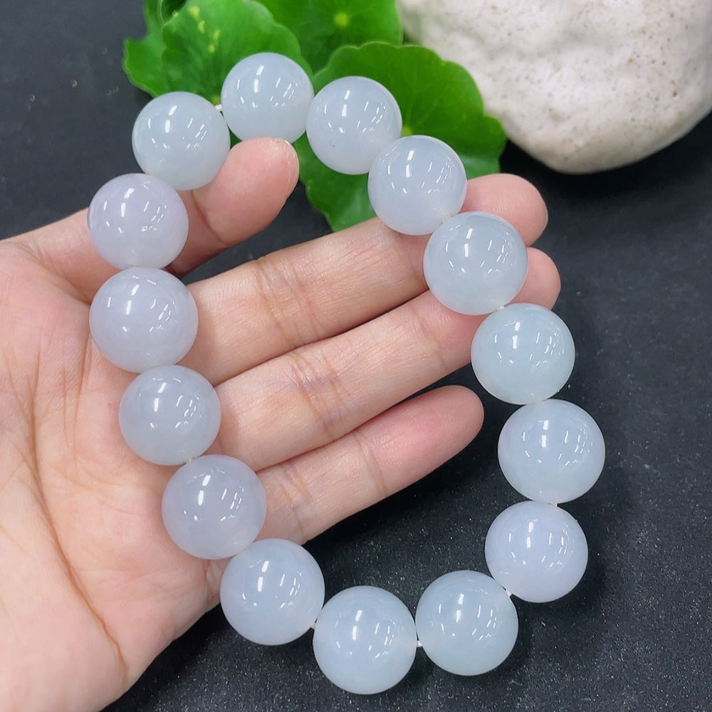 HKHQ jadeite bracelet featuring 15.4mm smooth, polished jadeite beads on a stretch cord, elegant and natural-looking jewelry piece.