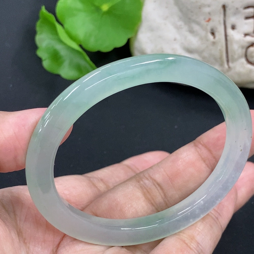 HKHQ jadeite oval bangle with size 55.3 and 24.3g weight, showcasing smooth, polished jadeite bracelet on a neutral background.