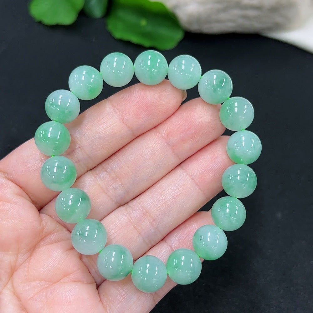 Close-up of a green jadeite bracelet from HKHQ, showcasing smooth, polished jade beads threaded together in a stylish design.