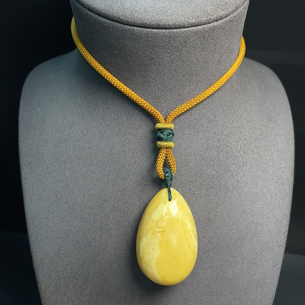 Amber beeswax pendant with rope necklace, HUILIU HQ certified amber jewelry, natural warm tones, detailed pendant design.