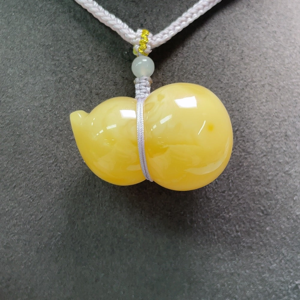 Amber beeswax pendant with Hetian jade and rope, crafted by HUILIU HQ, featuring natural amber and elegant design.