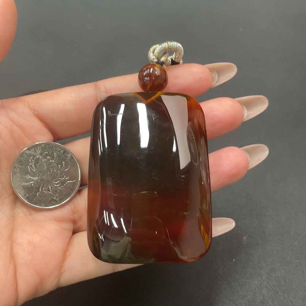 Amber beeswax pendant with rope necklace by HUILIU HQ, showcasing a warm amber stone on natural cord.