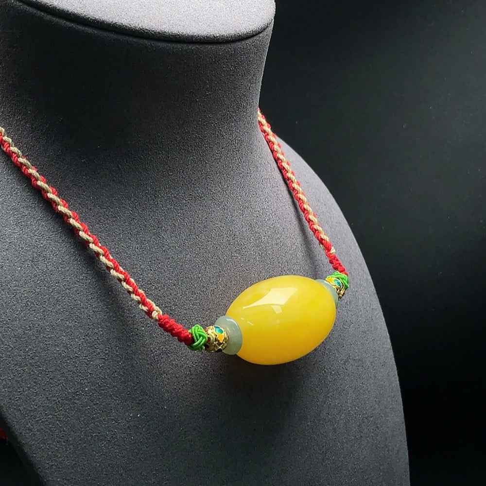Amber beeswax pendant with jadeite set on a rope necklace, crafted by HUILIU HQ, Huiliu certified jewelry.