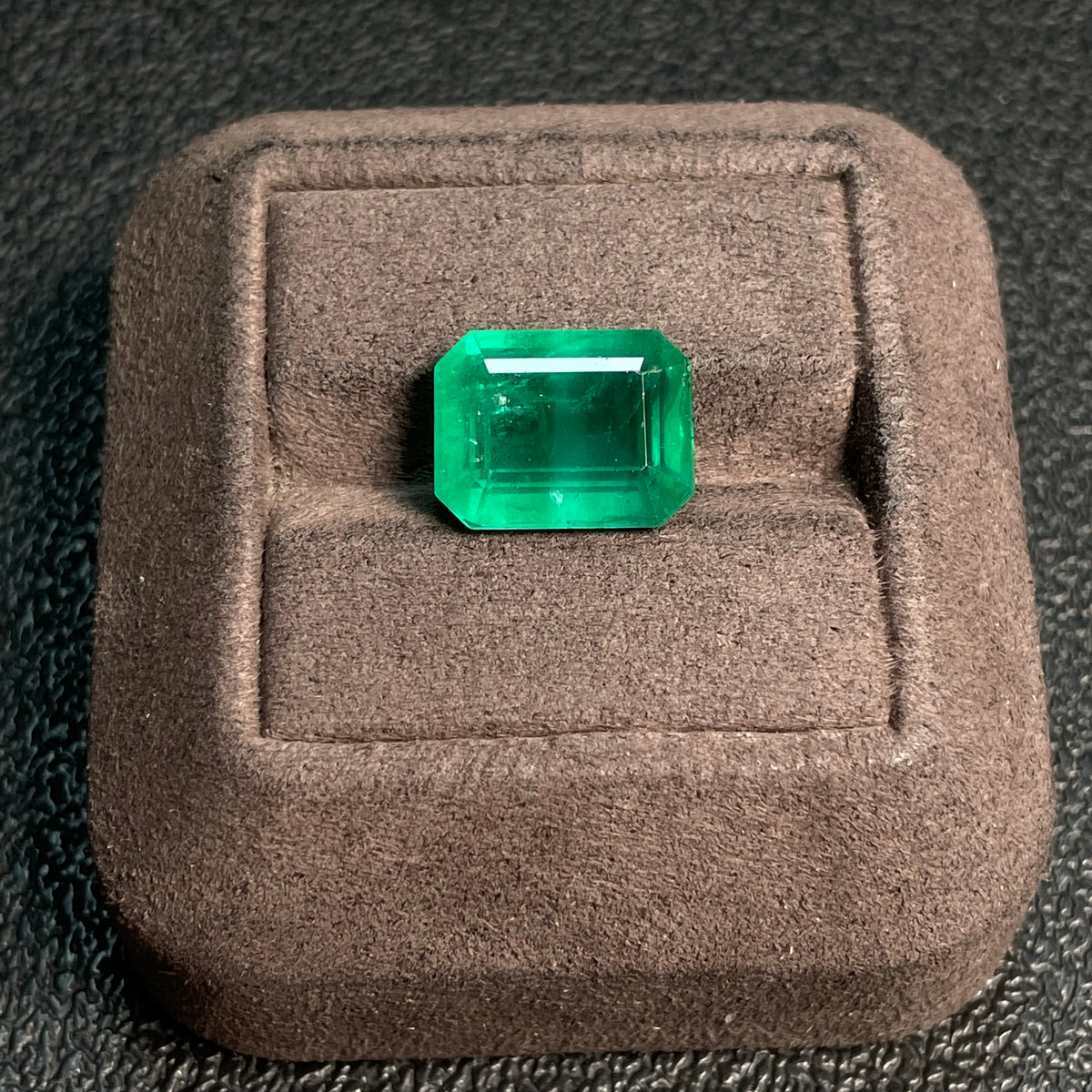 Vivid green emerald rough gemstone, 8.60 carats, clarity-enhanced, from Zambia, with GILDER certificate, minor oil treatment, natural state