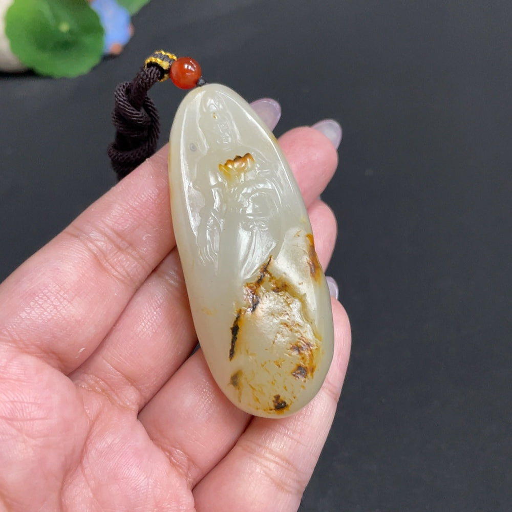 Hetian jade Guanyin pendant by HUILIU HQ, featuring intricate carvings of the Buddhist goddess on smooth, polished jade.