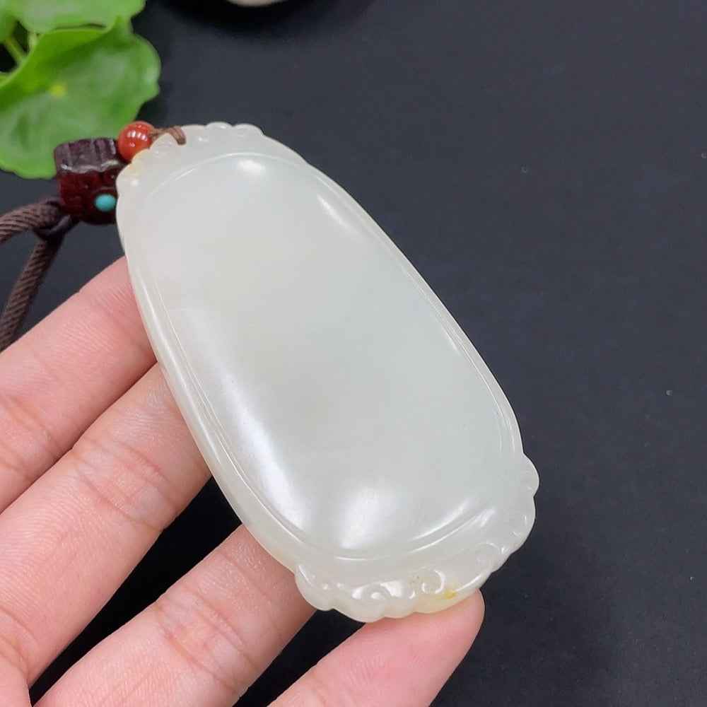 Huiliu Certified Hetian Jade Pendant with plain design, undetermined skin color formation, includes cord for wearing.